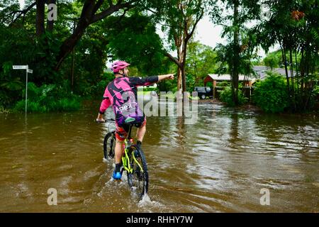 Les gens ride dans les eaux d'inondation sur les bicyclettes, Queensland, Australie. 3 2019. L'inondation a continué de s'aggraver à mesure que le déluge a continué et plus d'eau a été libéré de l'enflement du barrage de la rivière Ross pour empêcher l'échec de la mur de barrage. Crédit : P&F Photography/Alamy Live News Banque D'Images