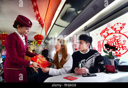 Tianjin. 3, 2019. Un accompagnateur de train propose une affiche du caractère chinois "Fu", qui signifie bonne chance, à des passagers à bord du G1709 Le train à grande vitesse d'Amérique du sud-ouest de la Chine Tianjin à Chongqing en Chine, le 3 février 2019, dans la perspective de la fête du printemps, ou le Nouvel An Chinois, qui tombe le 5 février cette année. Crédit : Yang Baosen/Xinhua/Alamy Live News Banque D'Images