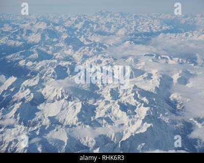 Paysage aérien des Alpes en Europe pendant la saison d'hiver avec de la neige fraîche. Vue de la fenêtre de l'avion Banque D'Images