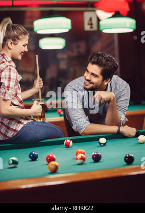 Jeune couple flirting in bar et jouer au billard ensemble Banque D'Images