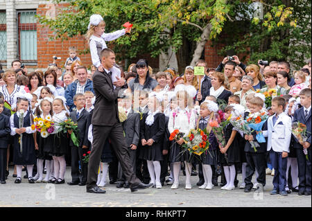 Tioumen, Russie - septembre 1, 2012 : l'école 43. Garçon plus âgé, adolescent, de race blanche, porte petit écolière avec la cloche. Première sonnerie dans la nouvelle année scolaire Banque D'Images