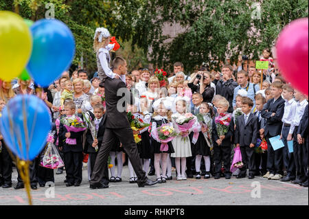 Tioumen, Russie - septembre 1, 2012 : l'école 43. Garçon plus âgé, adolescent, de race blanche, porte petit écolière avec la cloche. Première sonnerie dans la nouvelle année scolaire Banque D'Images