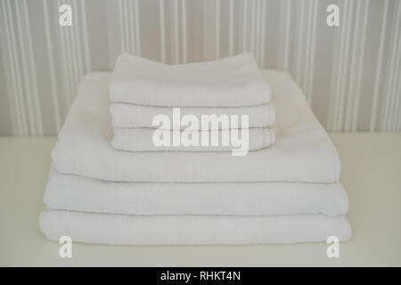 Une pile de serviettes blanches moelleuses dans la penderie. Service dans le concept de l'hôtel blanchisserie. Banque D'Images