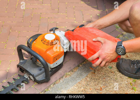 Jardinier homme taille-haie de remplissage de carburant Banque D'Images