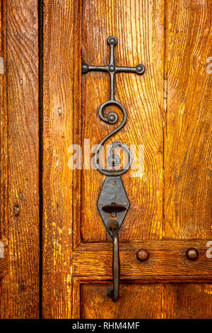 Croix de métal et la poignée sur une porte en bois, France Banque D'Images