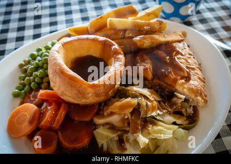 Tourte à la viande Steak chaud plaqué avec frites et sauce British repas sur une nappe vichy en plastique dans un café de Doncaster, dans le Yorkshire, Angleterre Banque D'Images