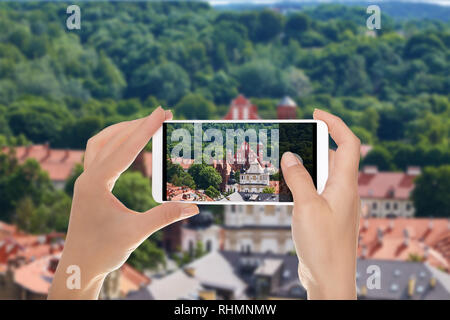 Un homme fait une photo du panorama de Vilnius, avec une vue sur l'église du Saint François Assise sur un téléphone mobile Banque D'Images