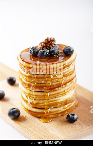 American Sweet des pile de crêpes ou de beignets à blueberry fruits, de noix et de miel, délicieux dessert pour le petit déjeuner, sur fond blanc. Sel Banque D'Images