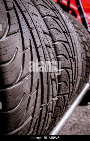 Détail de l'ensemble des pneus de voiture de course de la voie humide avec alignés sur une étagère, selective focus Banque D'Images