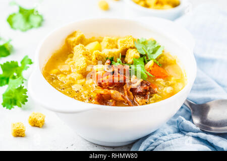 Split pea soup au lard fumé et craquelins dans une assiette blanche. Banque D'Images