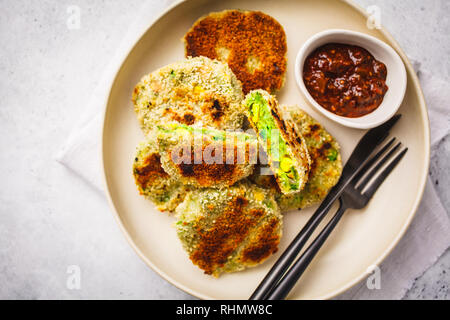 Veggie vert les escalopes dans un plat blanc avec sauce tomate sur fond blanc. Vegn saine food concept. Banque D'Images