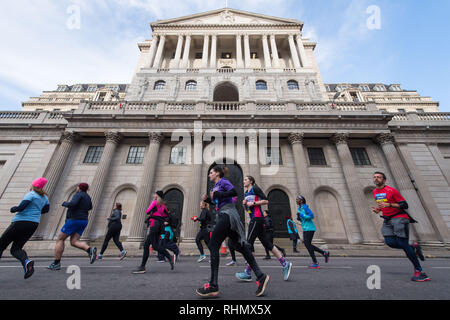 Glissières de passer la banque d'Angleterre, dans la ville de Londres, où ils prennent part à la Cancer Research UK London Winter Run. Banque D'Images