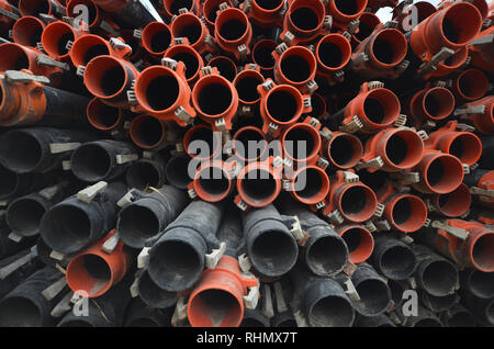 Arrière-plan de tuyaux en caoutchouc plastique. Grand groupe et pile de l'orange et le noir en plastique tuyaux de plomberie en caoutchouc. Tuyaux d'irrigation en plastique industriel pleine Banque D'Images