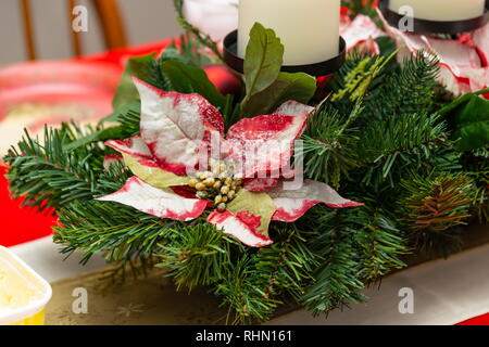 Un centre de table composé de pièce holly pine et bougies blanches Banque D'Images