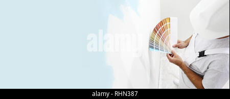 Homme peintre avec échantillons de couleur dans votre main, d'un choix de couleurs concept, sur grand mur vide pour copier l'espace et le fond de la bannière web Banque D'Images