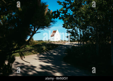 Le Sand-Covered Église entourée par des arbres à Skagen, Jutland, Danemark. Banque D'Images