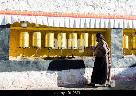 Femme tibétaine de tourner les roues de prière à Drepung, Lhassa, Tibet Banque D'Images