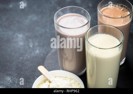 Des cocktails de protéines sur noir. La vanille, chocolat et fruits Boissons protéinées. La nutrition sportive. Banque D'Images