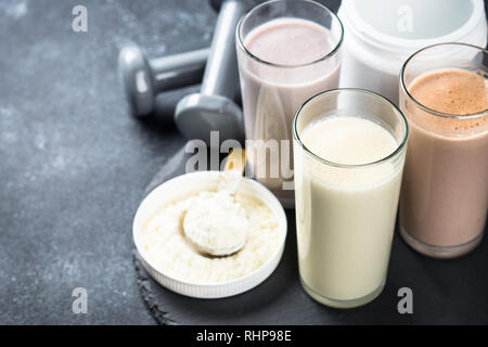 Des cocktails de protéines sur noir. La vanille, chocolat et fruits Boissons protéinées. La nutrition sportive. Banque D'Images