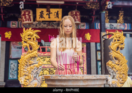 Encens sur joss stick pot sont en Feu et fumée utiliser pour payer le respect au Bouddha, encens en main femme et l'utilisation de fumée pour prier l'égard Banque D'Images