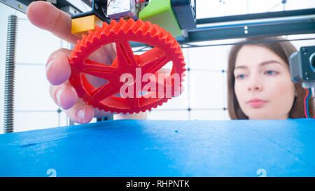 Les jeunes femmes designer dans l'impression 3D Lab. Fille prend le produit fini à partir de détails imprimante 3D Banque D'Images