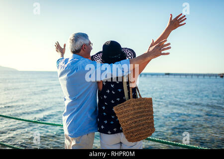 Senior couple raising arms sur la jetée en mer Rouge. Les gens célébrant les vacances. Valentine's day Banque D'Images