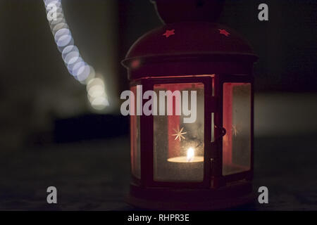 Lanterne Rouge avec l'étoile sur le verre et la gravure tealight dans l'obscurité Banque D'Images