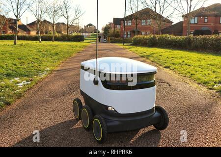 Les piétons passer au sujet de leur vie quotidienne en tant que technologies Starship robots autonomes faire les livraisons d'épicerie de routine autour de Milton Keynes. Banque D'Images