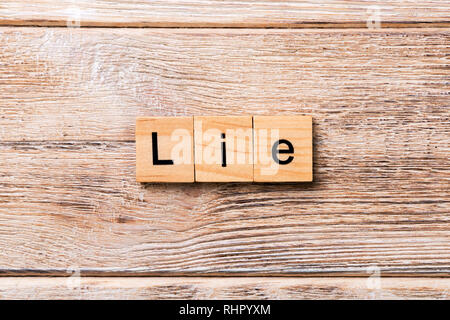Mensonge mot écrit sur une cale en bois. Mensonge texte sur table en bois pour votre conception, concept. Banque D'Images