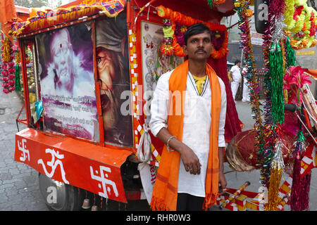 Un homme a mis son vélo dans un lieu de culte à saint indien Sai Baba de Shirdi, le culte a peint avec un Om (AUM) symbole et croix gammées, Mumbai, Inde Banque D'Images