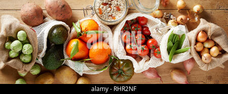 Assortiment de légumes biologiques frais vus du dessus sur fond de bois, paniers en tissu réutilisables sacs respectueux de l'environnement. L'épicerie du marché local b Banque D'Images