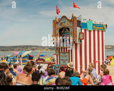 Un Punch et Judy show sur les sables à Weymouth, Dorset, Angleterre. L'un des deux seuls artistes actifs au 2018. Banque D'Images