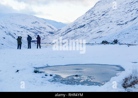 Les photographes à faire des photos de montagnes couvertes de neige des trois Sœurs du point de vue de A82 à Glencoe, Highlands, Scotland en hiver Banque D'Images