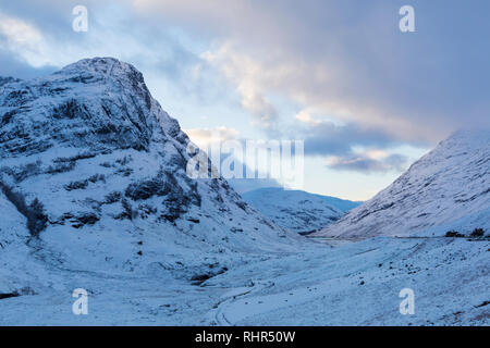 Crépuscule à la montagne couverte de neige des trois Sœurs du point de vue de A82 dans la région de Glencoe, Highlands, Scotland en hiver Banque D'Images