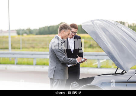 L'analyse de l'agent d'assurance de voiture panne lors de l'écriture sur le presse-papiers Banque D'Images