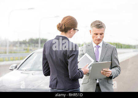 Agent d'assurance, de discuter avec plus de businesswoman contrat contre voiture panne Banque D'Images