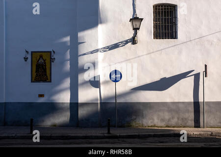 Scène de rue l'icône de l'Église Peinture des murs en plâtre blanc figure religieuse de base gris fer lanterne signe directionnel chaussée fenêtre barrée shadows Banque D'Images