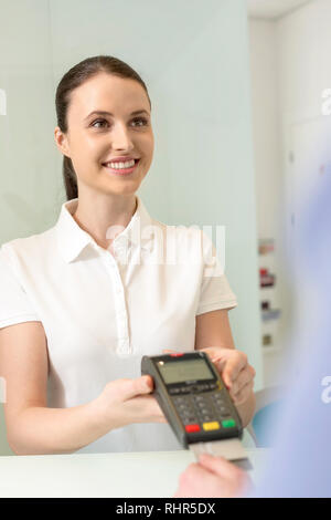 Jeune femme de vos paiements sur carte de crédit à la caisse en clinique Banque D'Images