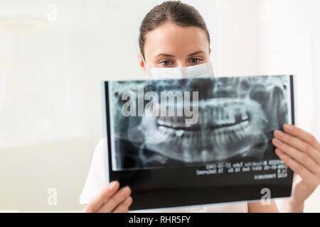 Dentiste confiant l'analyse de x-ray à une clinique dentaire Banque D'Images