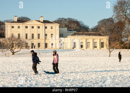 Sur un des hivers enneigés jour un couple marcher avec leur traîneau en face de Kenwood House, Hampstead, au Royaume-Uni. Banque D'Images