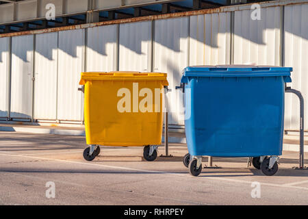 Des poubelles. Le bleu et le jaune des conteneurs de recyclage. Banque D'Images