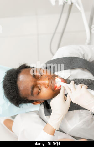 Avec une inspection caméra macro dentaire et affiche le résultat sur le moniteur. Jeune femme dentiste traitant des traitements de canaux dans la clinique dentaire. Man Banque D'Images