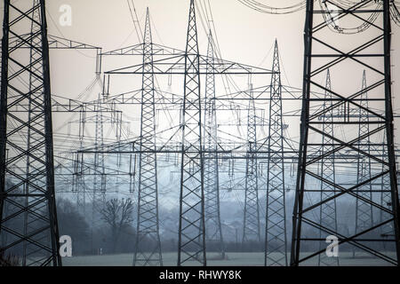 04 février 2019, en Rhénanie du Nord-Westphalie, Pulheim : poteaux d'électricité se tenir sur un champ au lever du soleil. Photo : Federico Gambarini/dpa Banque D'Images