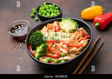 Nouilles udon asiatique avec sauté de brocoli, pois vert, la carotte et le poivre dans un bol. Cuisine asiatique oriental savoureux Banque D'Images