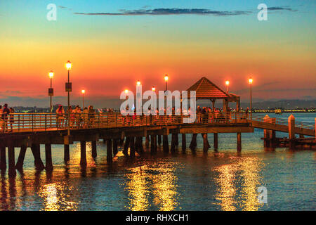 Vue panoramique sur le coucher du soleil de Coronado Ferry Landing sur Coronado Island, Californie, USA. Les gens et les touristes marcher sur l'ancienne jetée en bois reflétant à San Banque D'Images