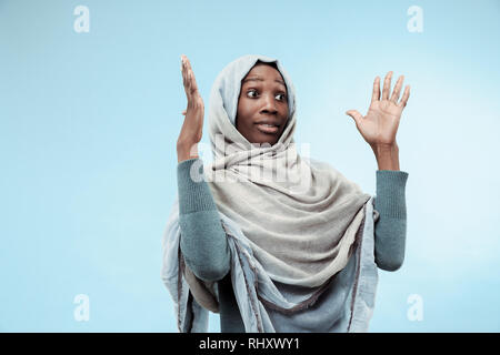 La belle jeune fille musulmane d'Afrique noire portant le hijab gris bleu au studio. Elle a surpris l'émotion sur son visage. Les émotions humaines, l'expression faciale concept. Couleurs tendance Banque D'Images