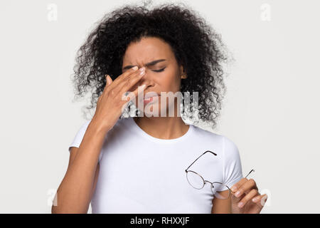 Bouleversé femme afro-américaine à partir de la fatigue oculaire de tête Sensation longtemps porter des lunettes Banque D'Images