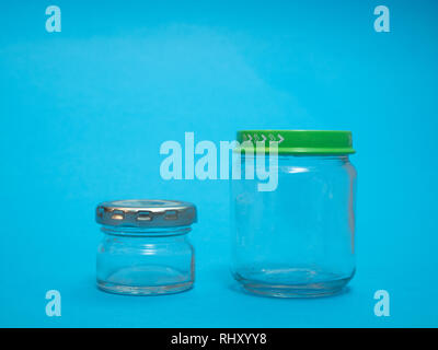 Deux pots de cuisine en verre vide sur fond bleu. confiture ou épices storage Banque D'Images