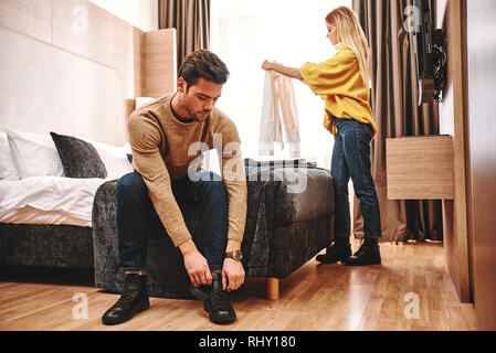 Temps de départ. Couple checking out leur location de vacances appartement, ils recueillent les choses après les vacances de noces Banque D'Images