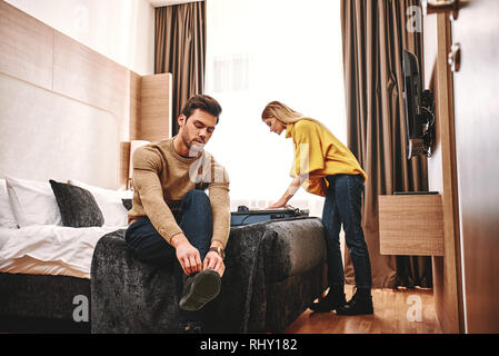 Collection les choses après les vacances. Couple checking out leur location de vacances appartement, ils recueillent les choses après les vacances de noces Banque D'Images